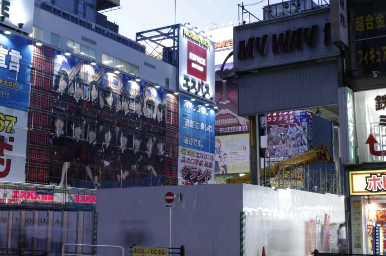 an intersection in an asian city with many advertits on the buildings