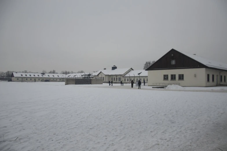 two people standing in the snow beside a building