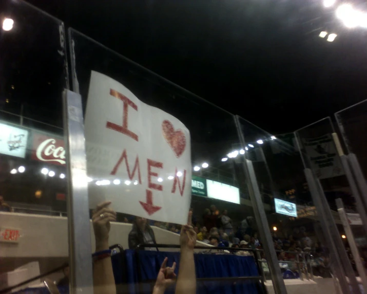 people holding a sign that reads i love me in front of a crowd