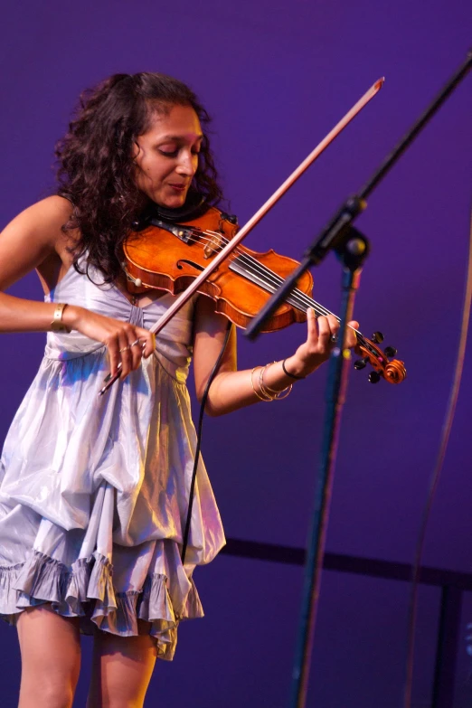 the woman is playing violin by her stage