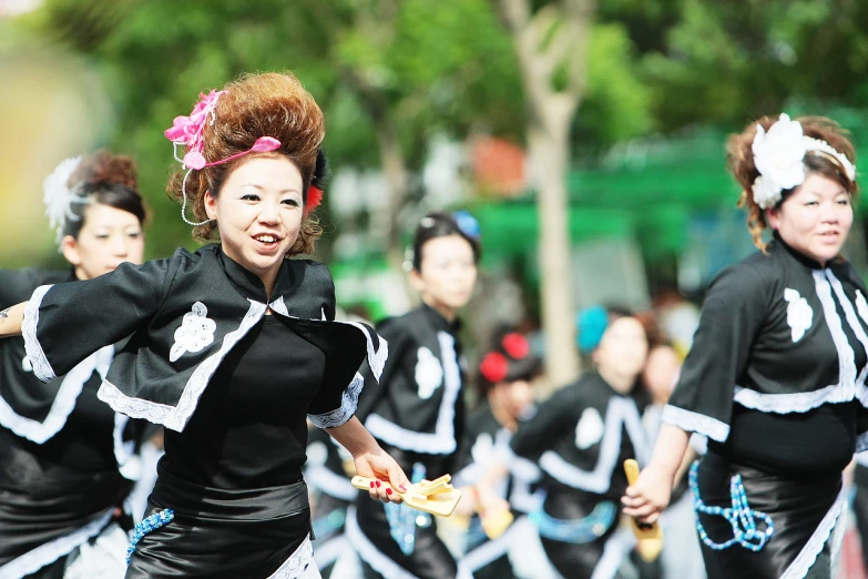 a line of people dressed in costume and standing on one side with their arms outstretched