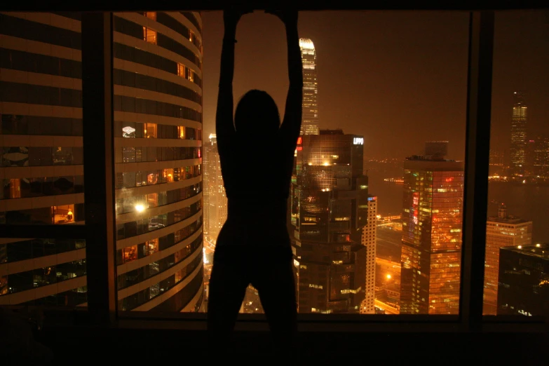 woman holding an umbrella in front of window at night