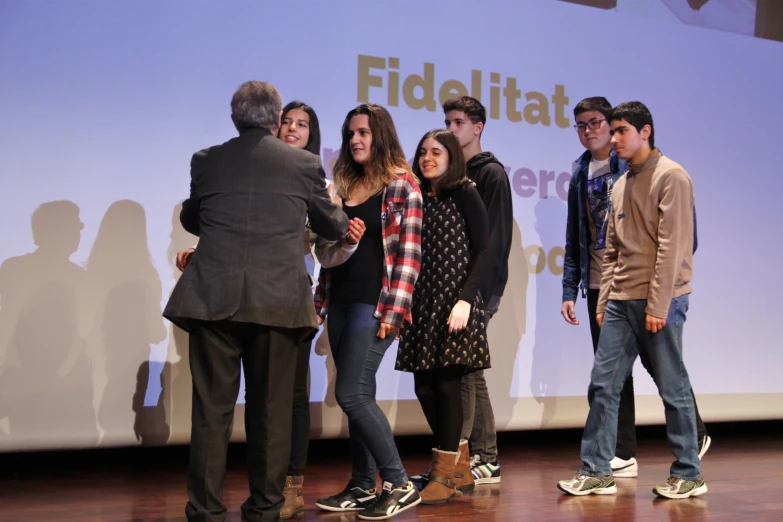 a group of people stand in front of a projection screen