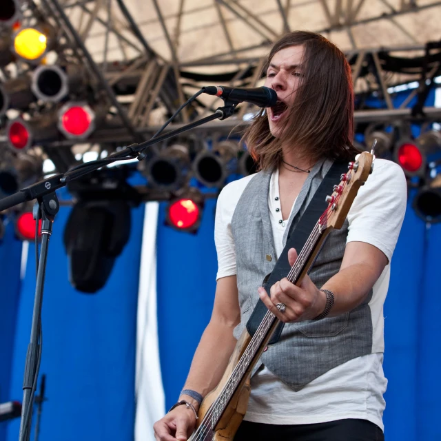 the guitarist smiles while playing on the stage