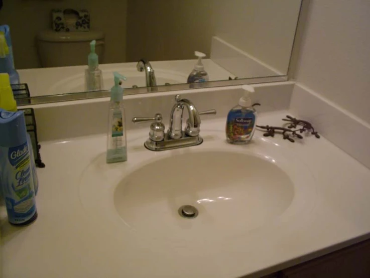 a bathroom sink with several bathroom items sitting on top of it