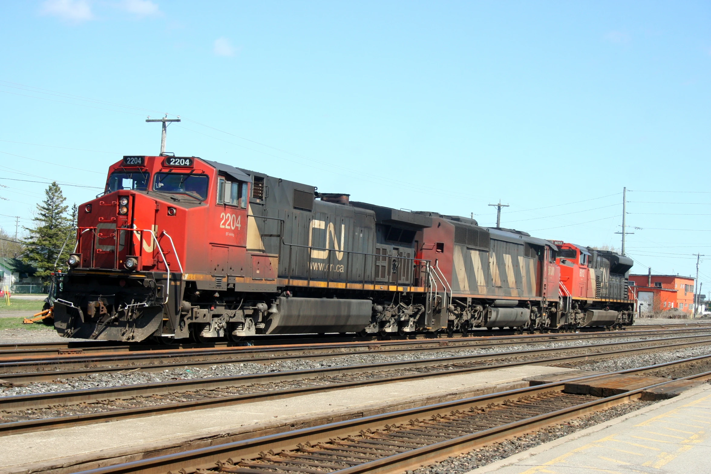 a red train traveling past a bunch of train tracks