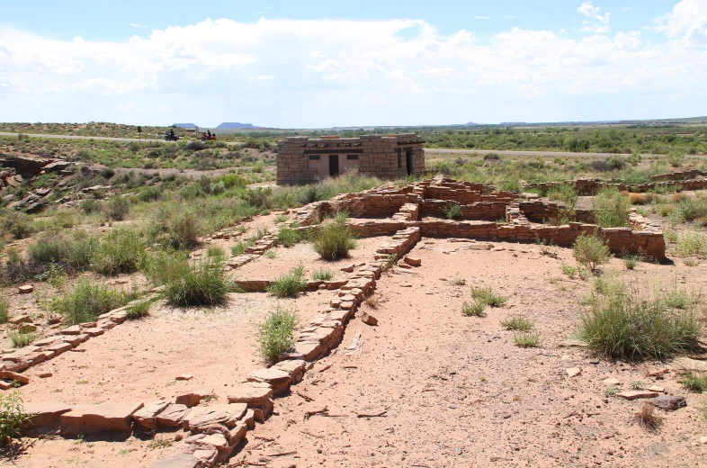 an old building sits in the middle of a desert