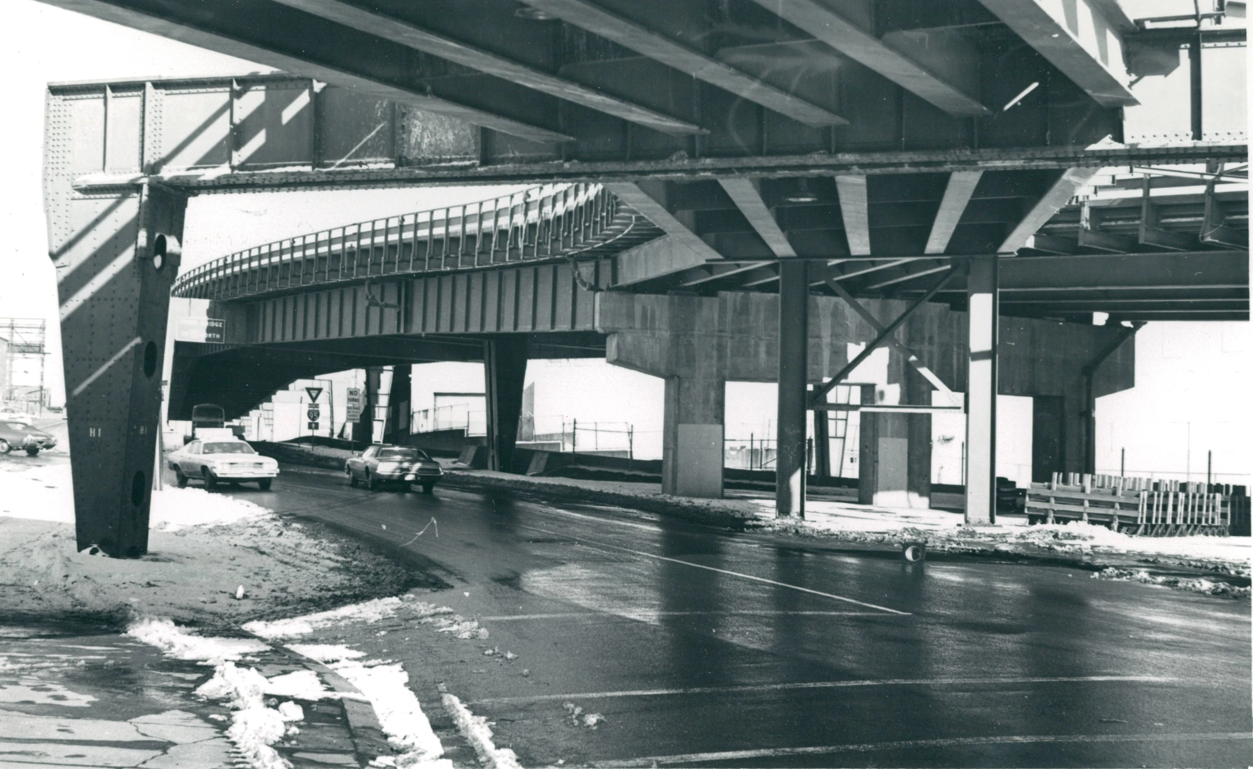 there is a street under the bridge and cars