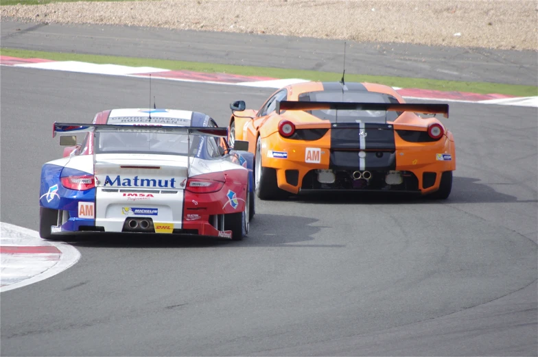 two cars in racing on the track during the day