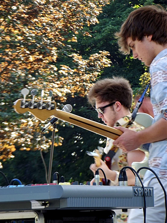 a pair of men singing on stage playing guitars