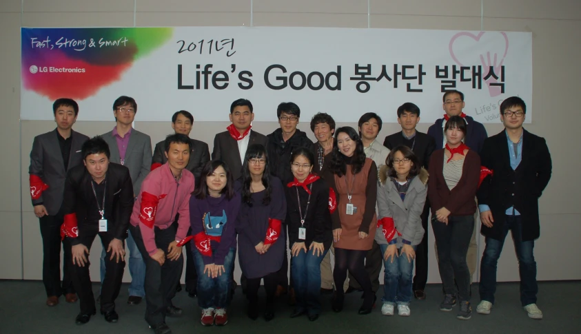 a group po of asian people posing with a sign