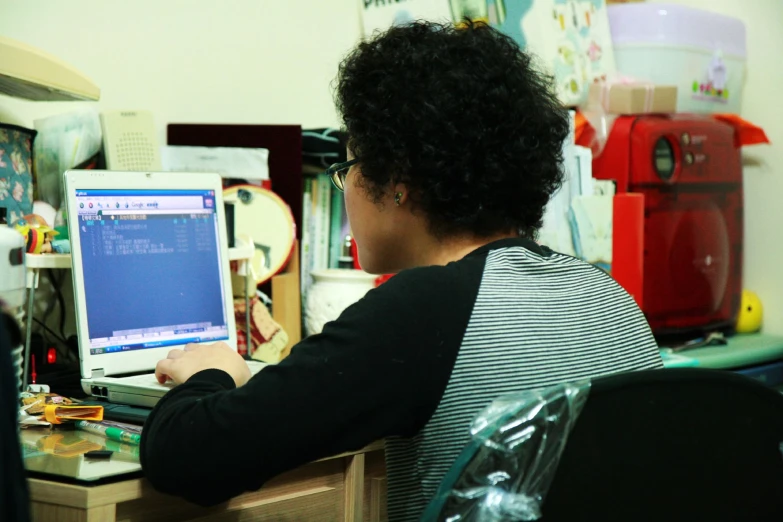 a person sitting at a desk typing on a laptop computer