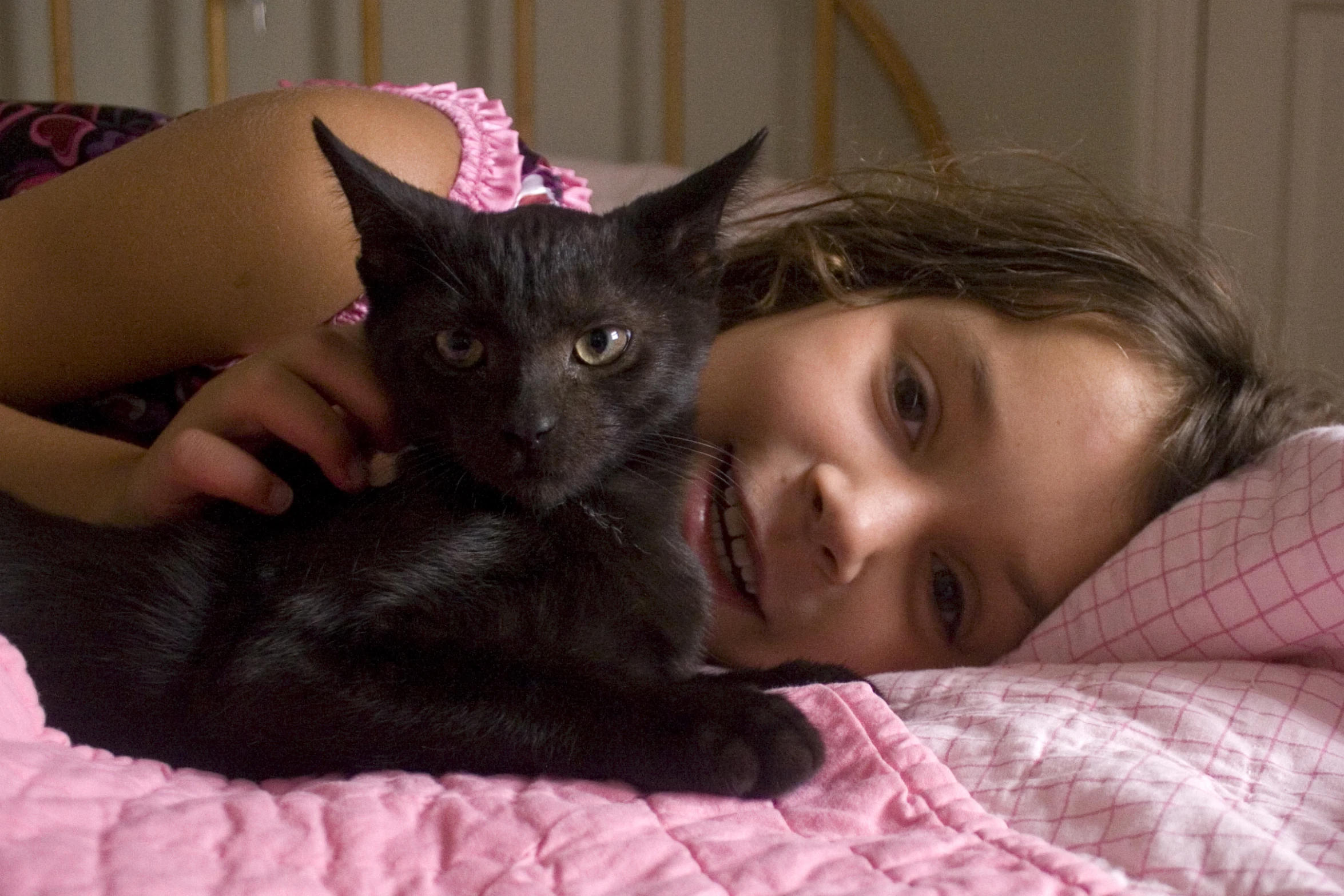 a girl laying in bed holding onto her cat