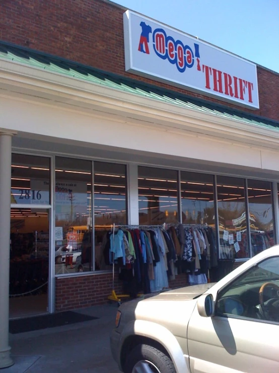 a car in front of the store with a white suv parked outside