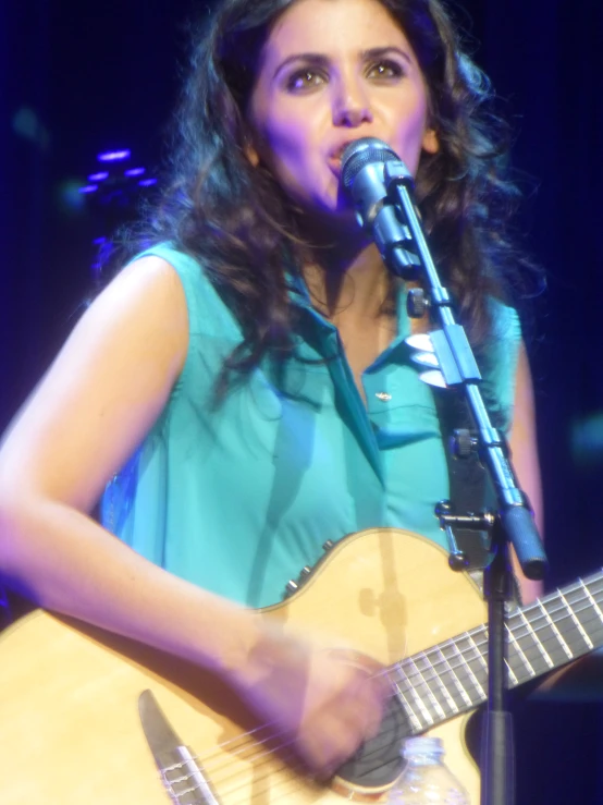 a woman with long hair is holding a guitar