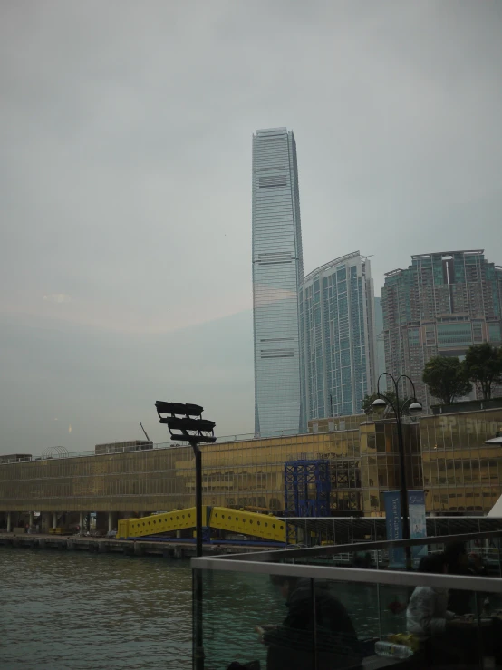 a very tall building near the water on an overcast day