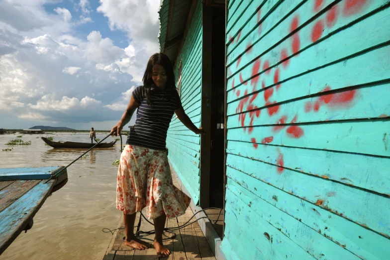 a woman is holding a dog on a dock