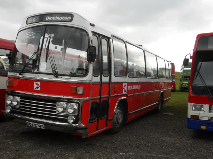 two buses are parked side by side in a field