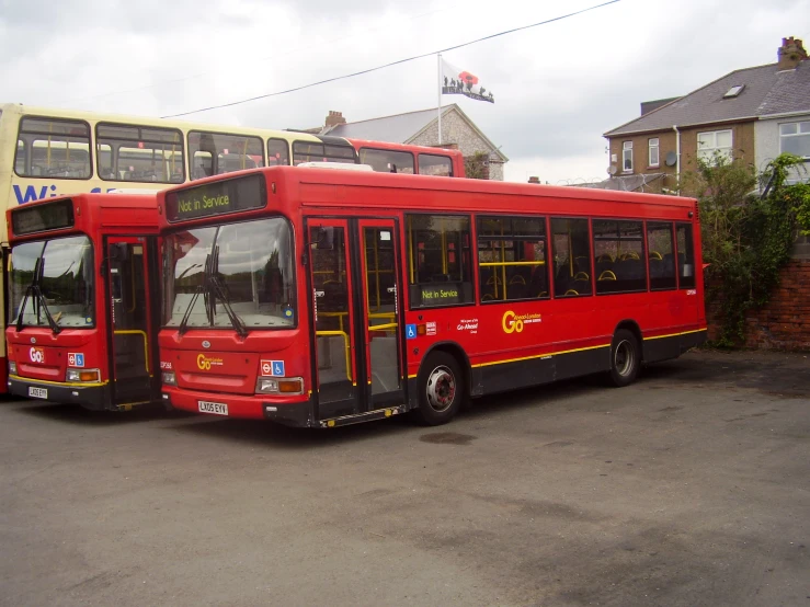 two passenger buses are parked in a parking lot