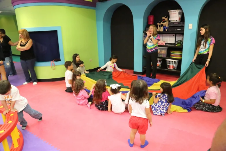 children playing in a play area while adults watch