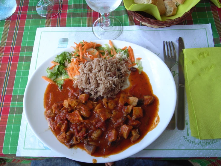 the white plate has rice and meat on it