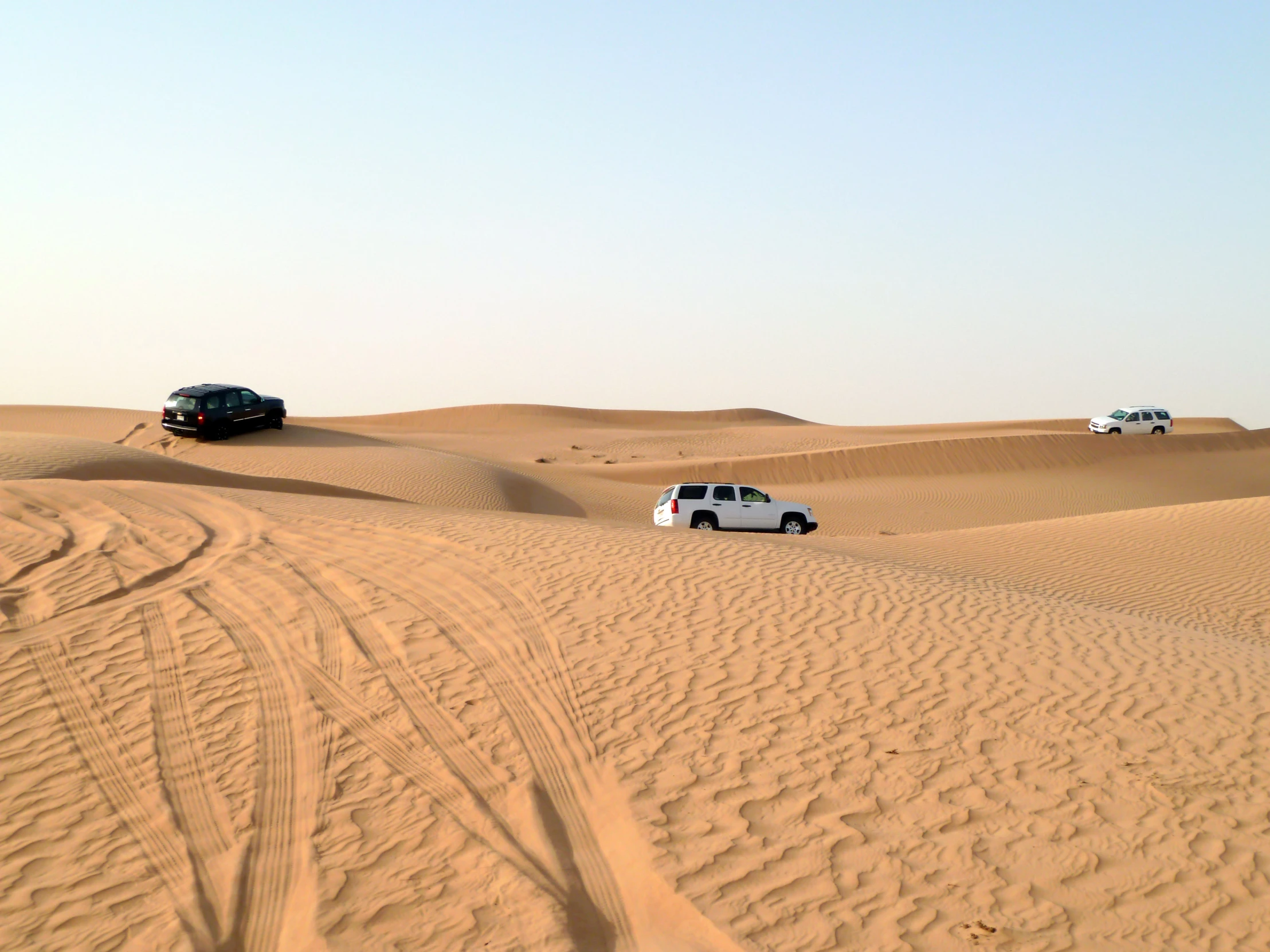 a car and truck stuck in the middle of a desert