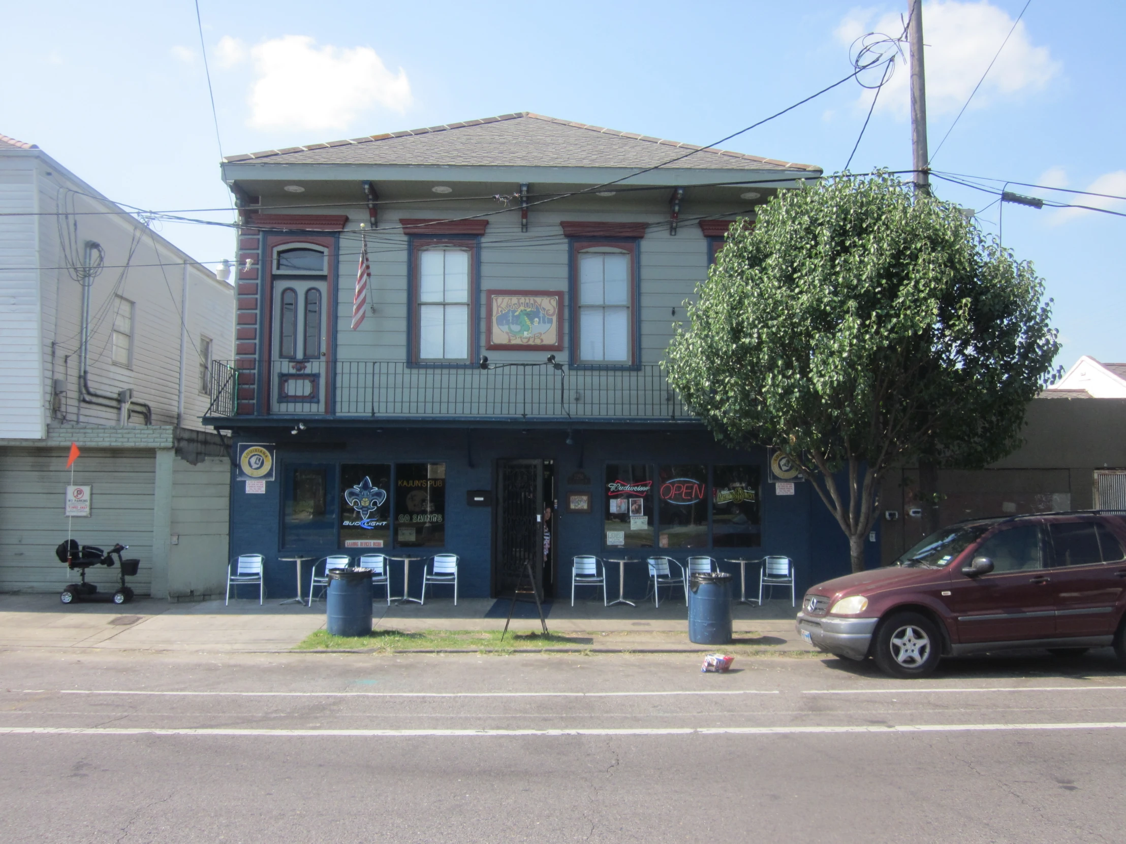 there is a small blue building on the corner of a street