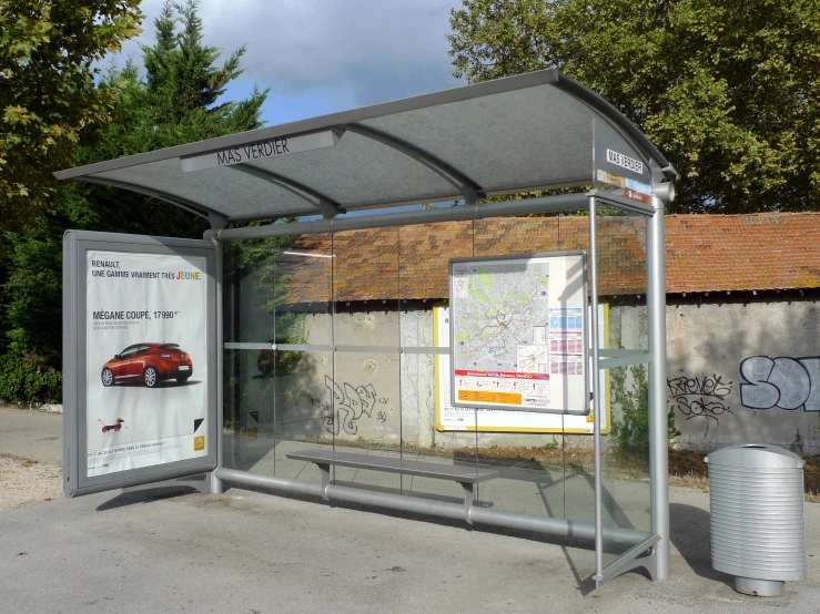 an outdoor bus stop with signs and graffiti on it