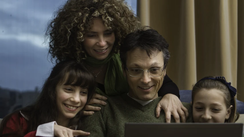 a man and two s are sitting together on the lap of a computer