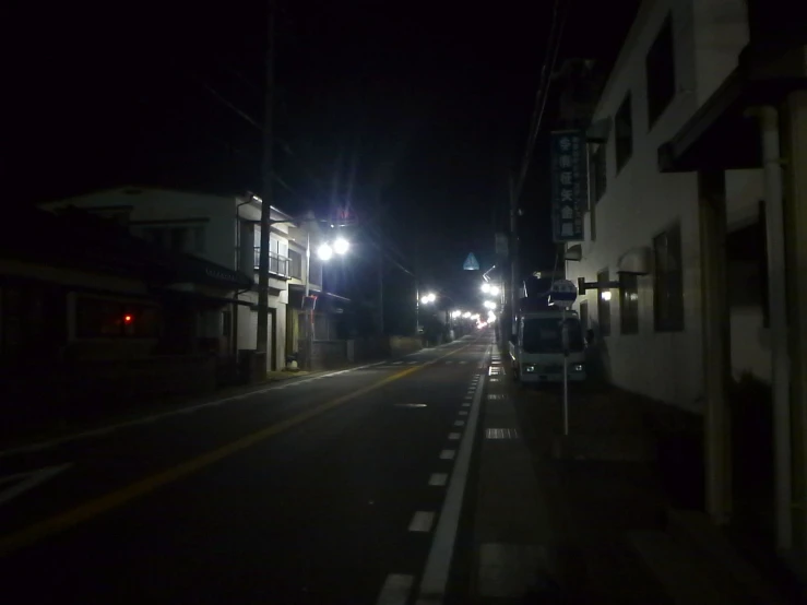 a small city street at night with traffic lights on