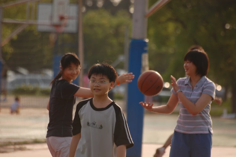 a girl is holding a basketball and playing with two other girls