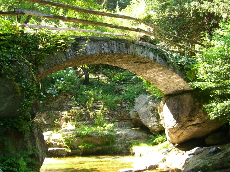 a river running under an old stone bridge