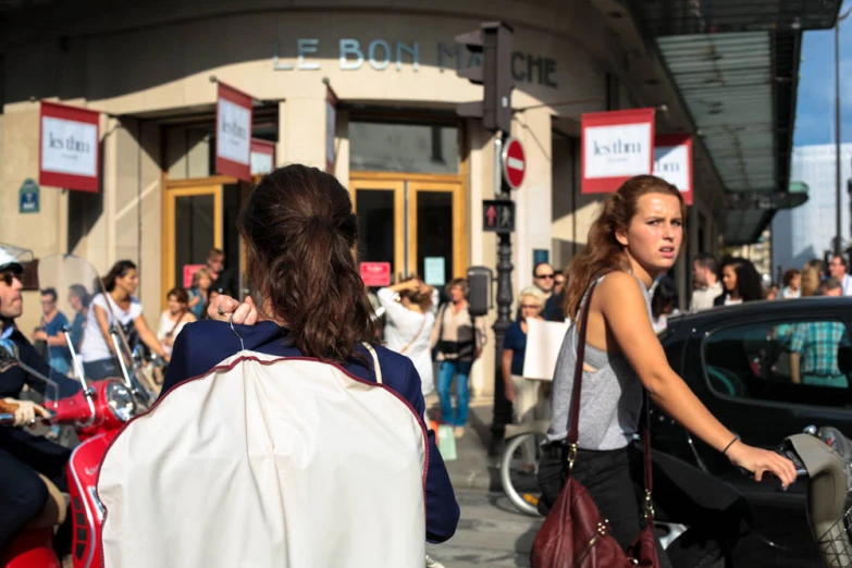 several people walking around on a busy sidewalk