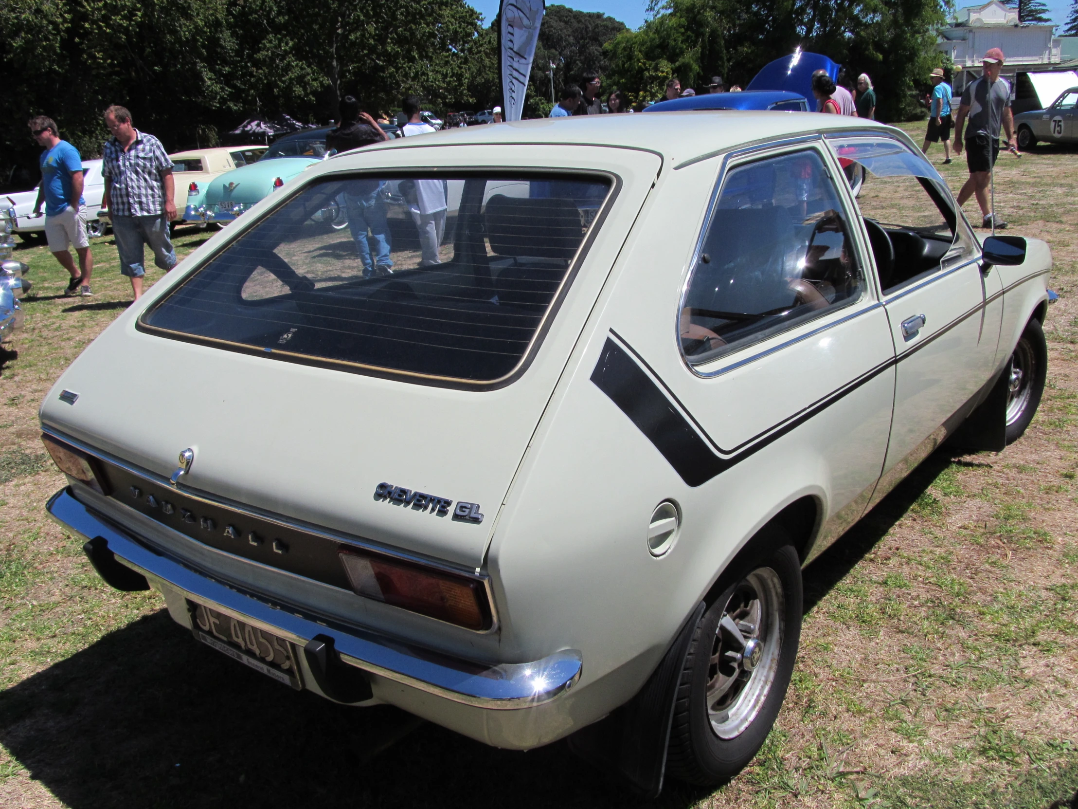 a vintage car parked in the grass during the day