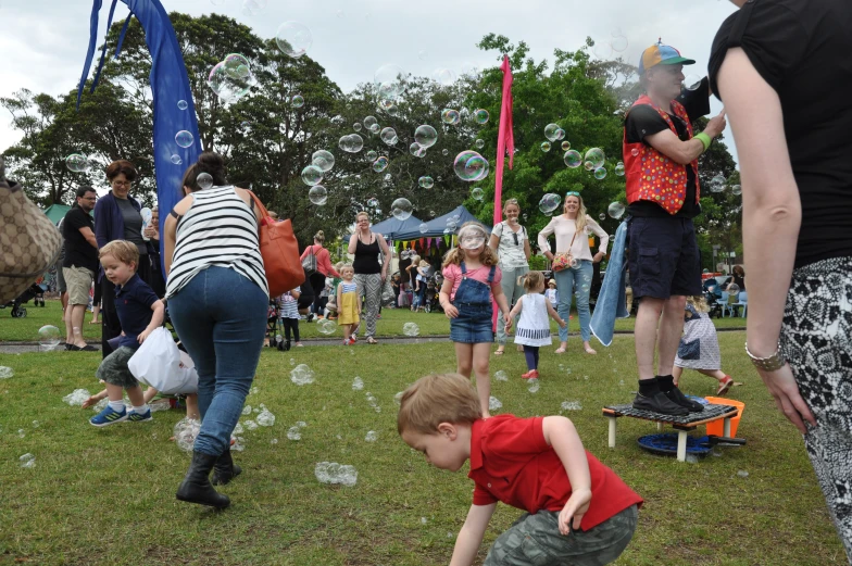 some people standing around with bubbles of soap