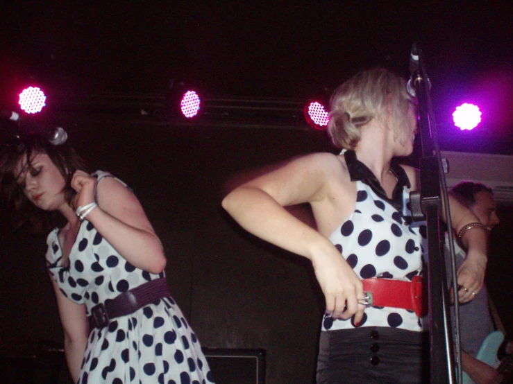 two girls in polka dot tops performing at a concert