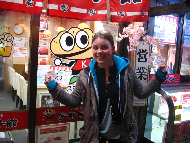 a person holding soing and making a silly face in front of a display case