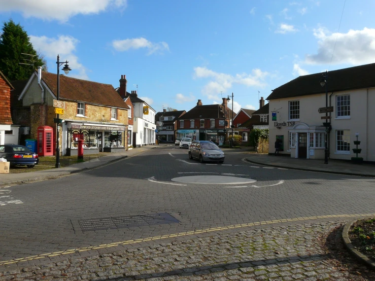 a road with several stores and cars parked at each end