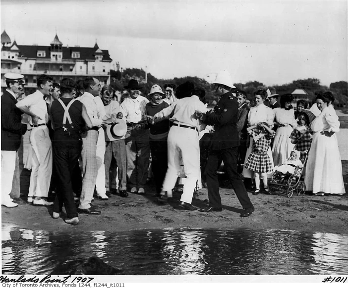 a group of people standing near water with one person taking a po