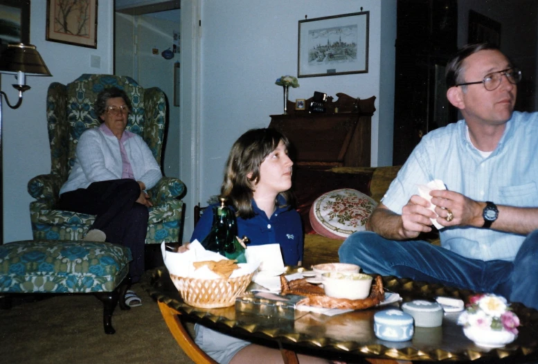a man sitting in a chair next to a little girl