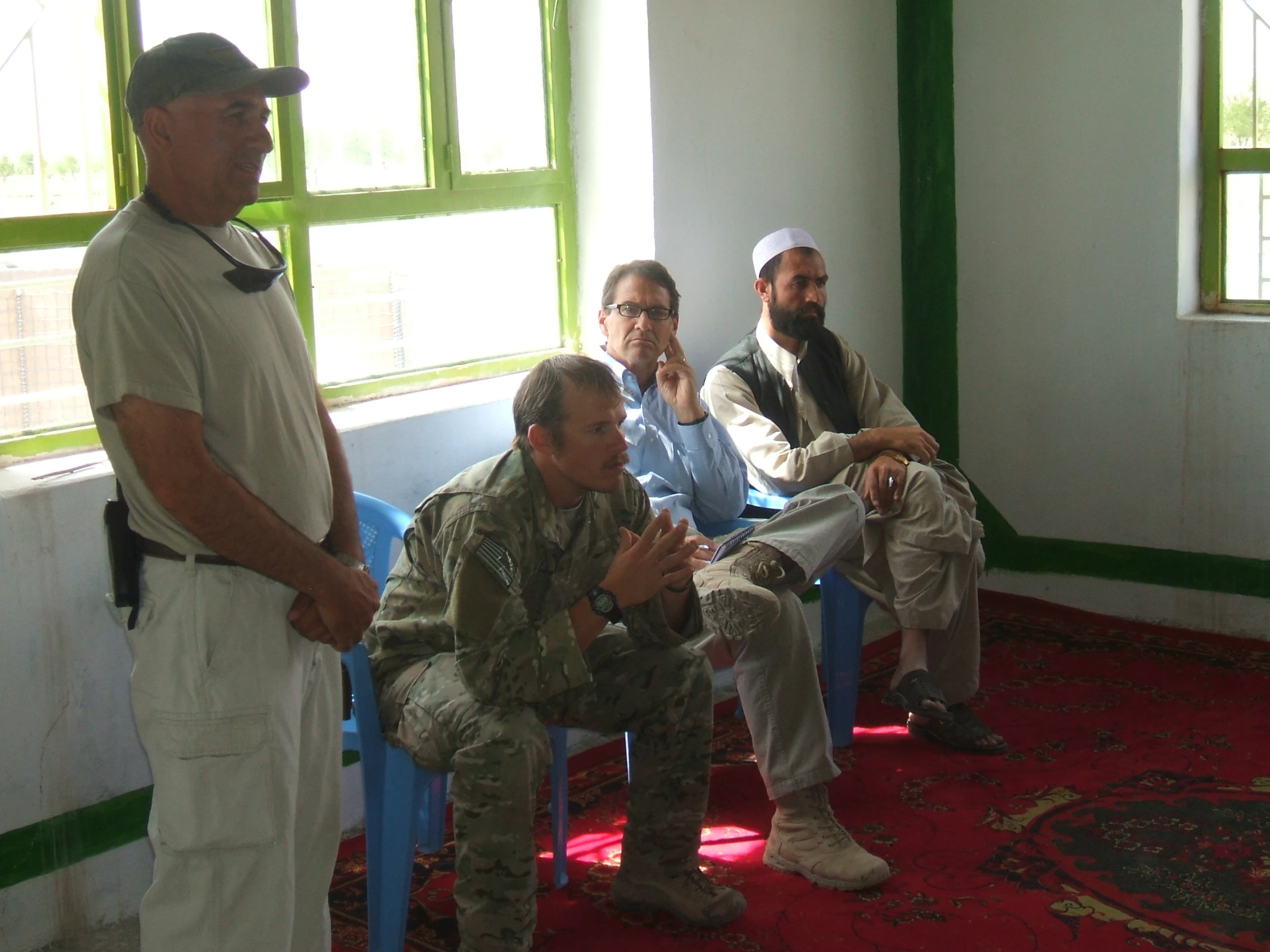 a group of men sitting and standing in a room