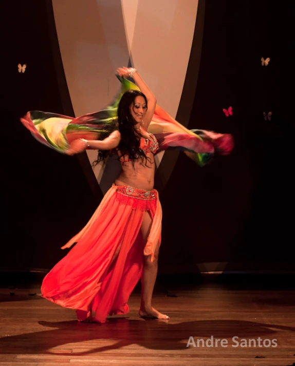 a dancer performs with a multicolored gown on stage