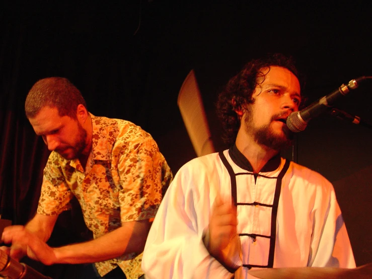 two men on stage with instruments playing musical instruments