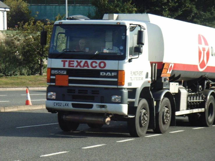 a cement truck driving down a road behind traffic cones