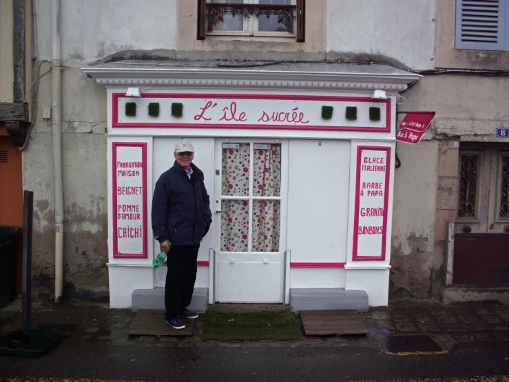 a man standing at the entrance to a shop with a banner on it