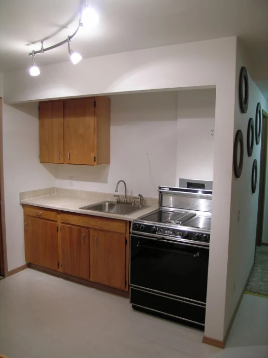 a stove and sink in a kitchen with wood cabinets