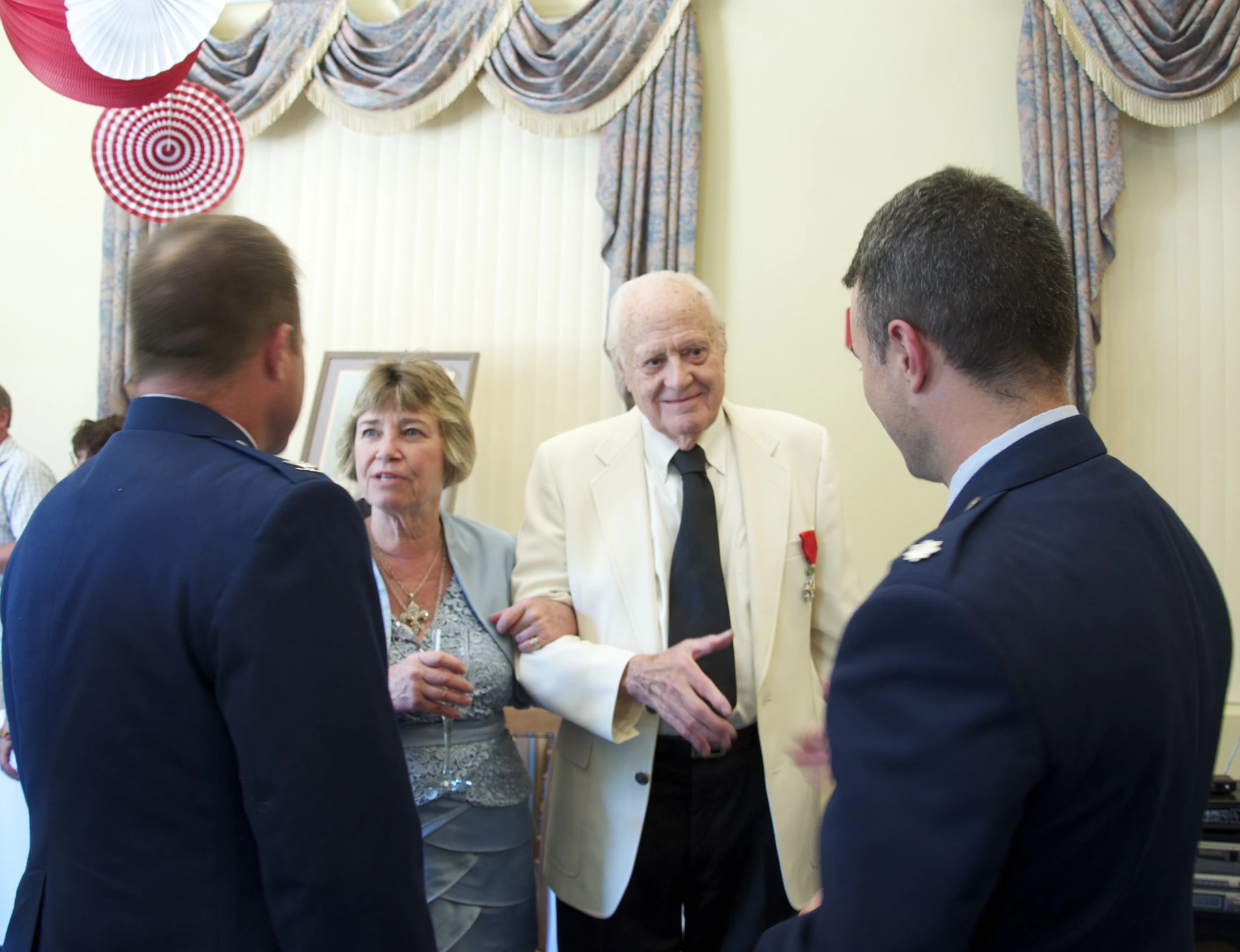 a man in suit talking to three other men in suits