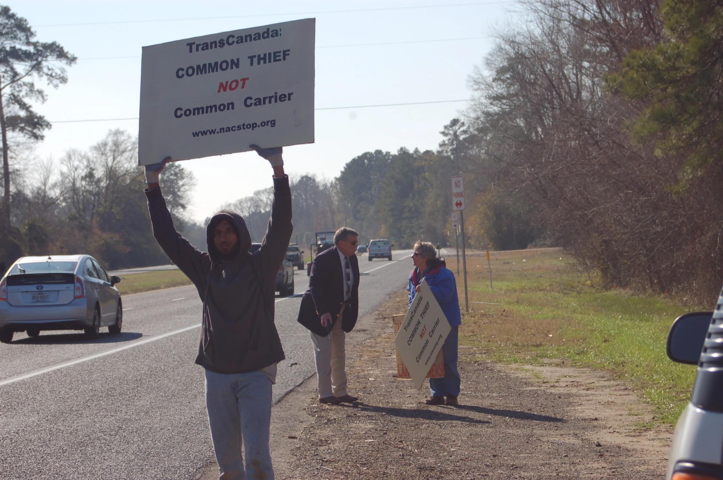 people with their arms up and signs in front of them