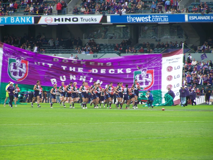 a rugby game with a banner in the background