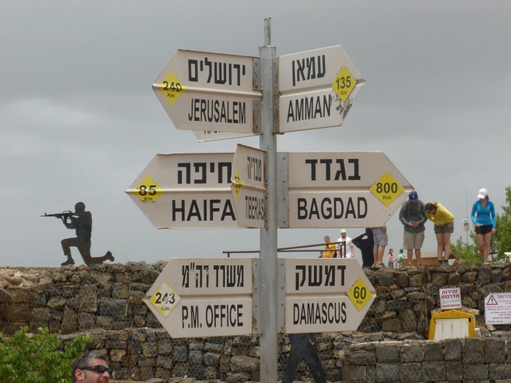 a group of people standing around with signs in front of a stone wall